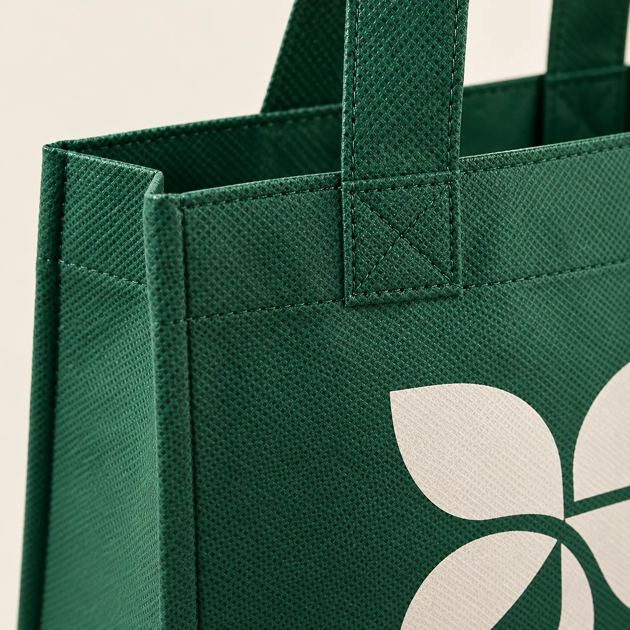 Close-up of the green non-woven tote's bonded-fiber texture