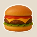 Realistic cheeseburger puffy sticker mockup from PuffSticker.com featuring a golden-brown bun, juicy beef patty, melted yellow cheese, crisp green lettuce, and a layer of red ketchup. Designed with a soft 3D foam texture, this sticker captures the mouthwatering appeal of a classic burger. Ideal for food brands, restaurant giveaways, or playful packaging, it combines tactile charm with vibrant detail. Printed on durable adhesive material, it’s easy to peel and long-lasting. A fun and flavorful way to promote culinary creativity or add personality to everyday items.