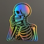 Holographic vinyl sticker featuring a side-profile skeleton in a thoughtful pose, resting its cheek on one hand. The design is enhanced with a rainbow sheen that shifts with light, creating a visually striking and reflective effect. Printed on clear vinyl with smooth contour edges. Designed by PuffSticker.com for gothic-themed sticker sets, anatomy-inspired art, and alternative stationery collections.