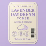 Clear waterproof bottle label for Lavender Daydream Toner from PuffSticker.com featuring soft pastel tones, serif typography, and wellness icons (paraben-free, aloe vera, cruelty-free). Includes product volume, barcode, and soothing slogan. Ideal for skincare packaging with elegant shelf appeal.