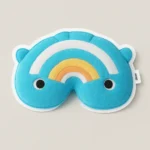 Custom foam sticker mockup featuring a whimsical rainbow-shaped character with plush-like styling. Designed with vibrant blue, white, yellow, and orange stripes, this soft EVA sticker includes playful details like black eyes and small ears, adding charm and personality. Ideal for children’s crafts, packaging, or themed giveaways, the sticker offers a tactile, flexible surface with strong adhesive backing. Waterproof and die-cut for easy application, PuffSticker.com’s foam labels combine fun design with durable quality, making them perfect for creative branding and personalized gifts.