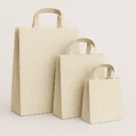A set of three washable paper bags in white color in different sizes, crafted from eco-friendly, cellulose-reinforced, water-resistant paper. These durable, vegan-friendly bags feature sturdy handles and a leather-like texture, ideal for shopping or gifting. Customizable with brand logos, they are offered by PuffSticker.com with global delivery options.