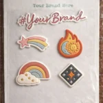A vertical display sheet of custom PU stickers featuring a colorful rainbow, star, and sun-moon flame design. Each sticker shows a soft, raised convex effect and a matte, leather-like grain texture.