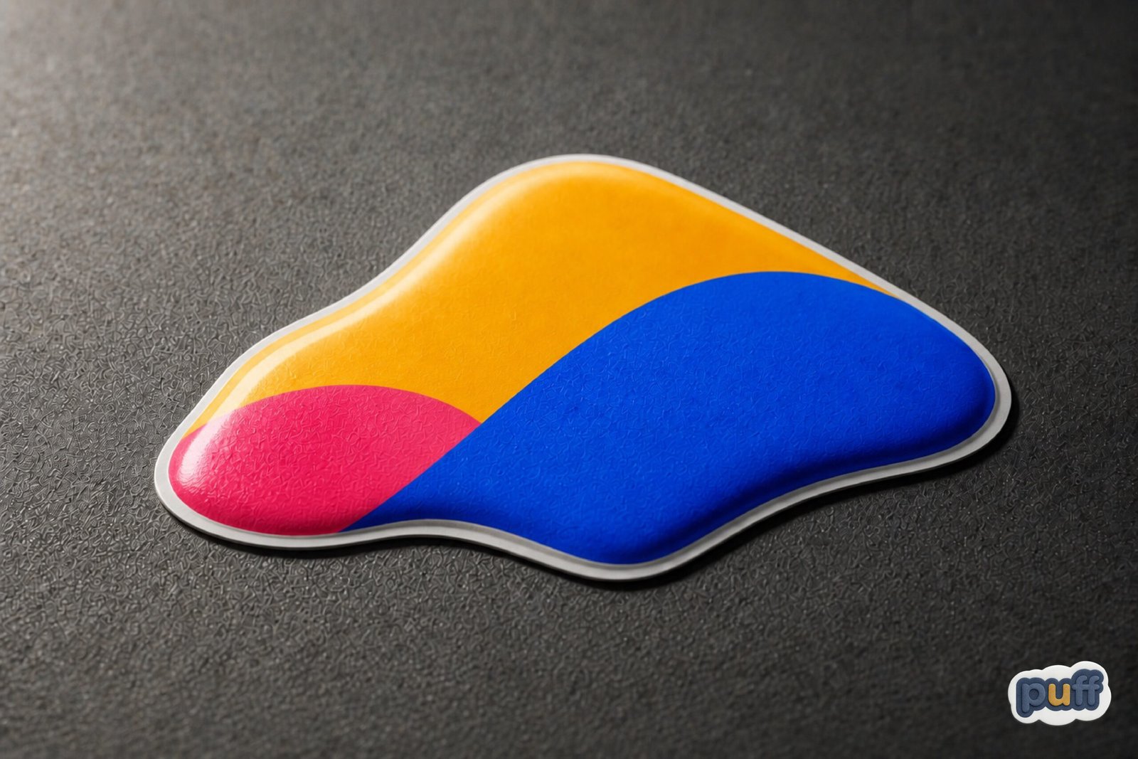 Vibrant custom puffy sticker in cobalt blue, golden yellow, and coral pink, showing its raised dimensional surface and white edge.