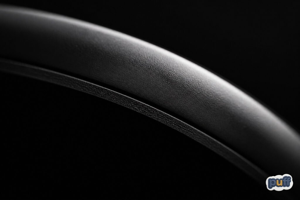 Why Some Custom Stickers Feel Like Objects 6 Abstract macro photograph of light catching the raised edge of a dimensional custom sticker against a dark background